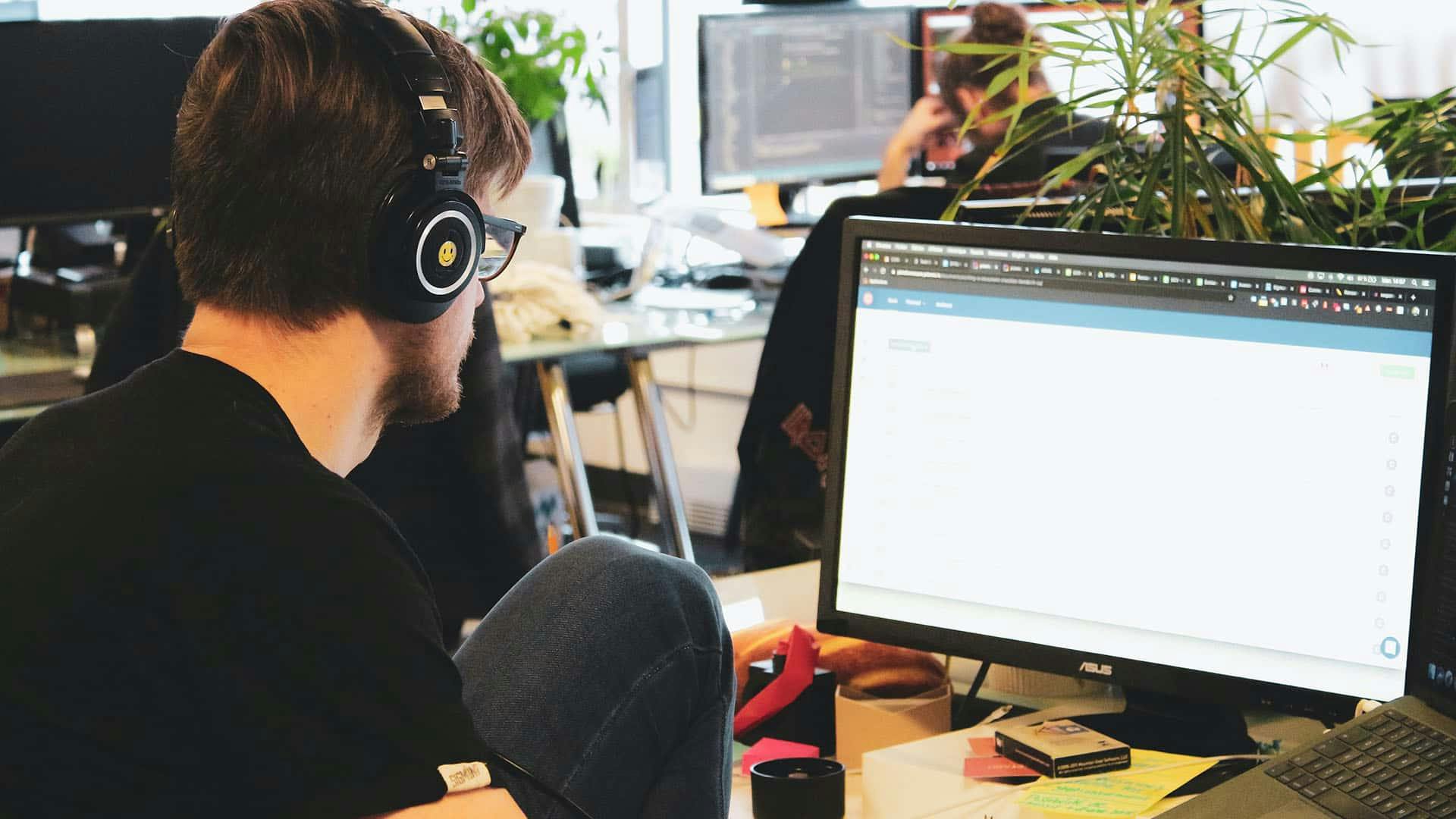 man in black shirt wearing black headphones working on a website